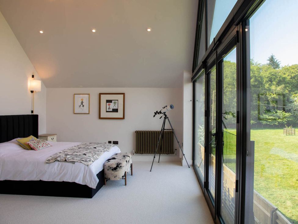A bedroom with bed and telescope at House Sleeps 10 with Enclosed Garden Checkendon near Henley-On-Thames