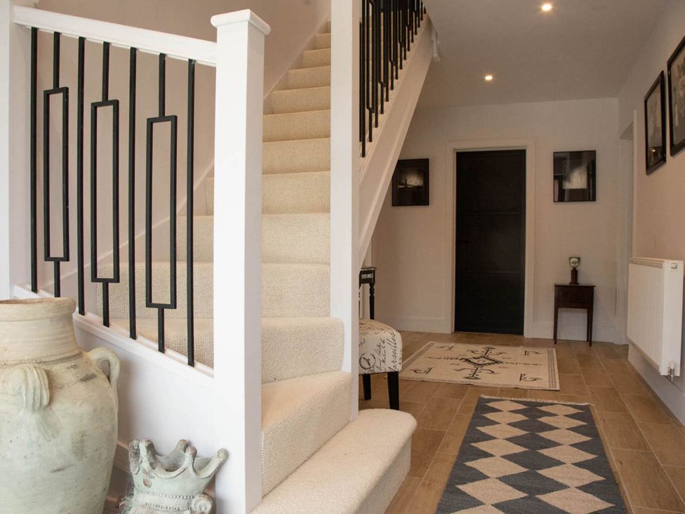 A hallway with a staircase and decorative vase at House Sleeps 10 with Enclosed Garden Checkendon near Henley-On-Thames