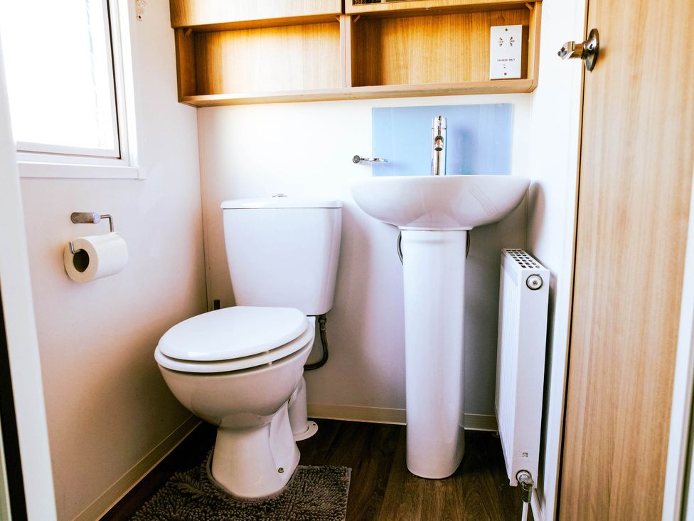 A bathroom with a toilet and sink at Captivating 6-Person Caravan in Rhyl