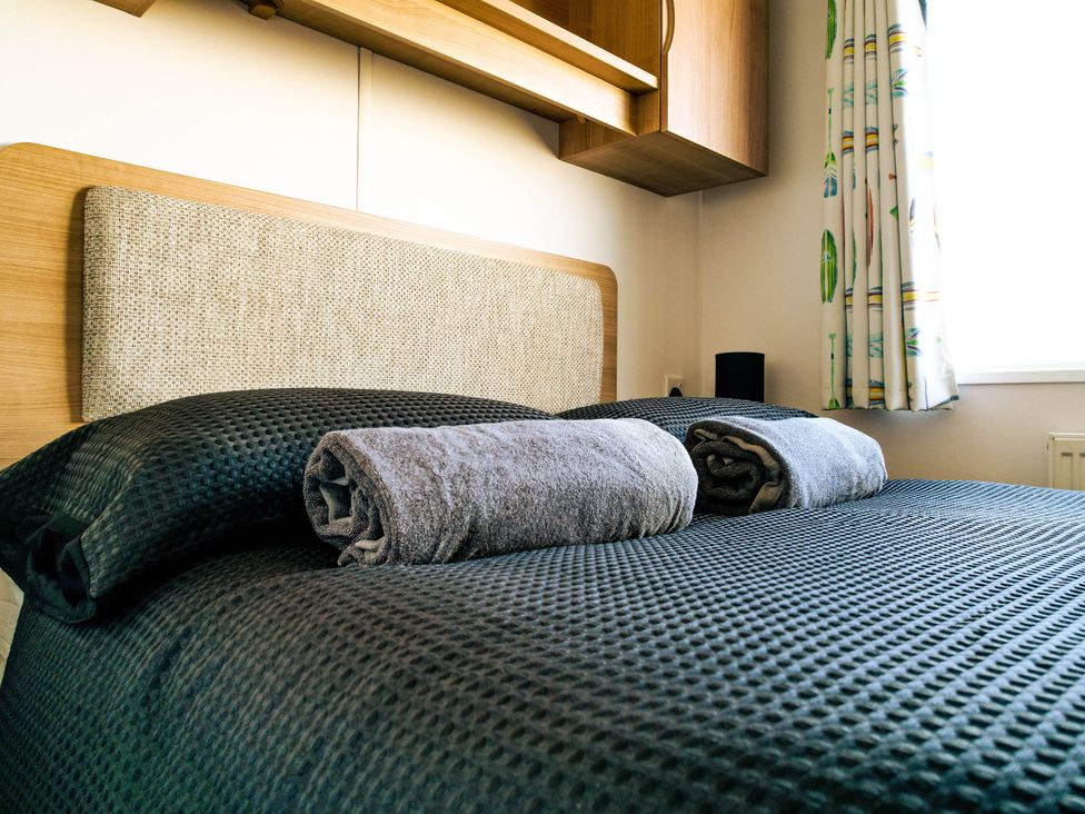 A bed with pillows and towels in a bedroom at Captivating 6-Person Caravan in Rhyl