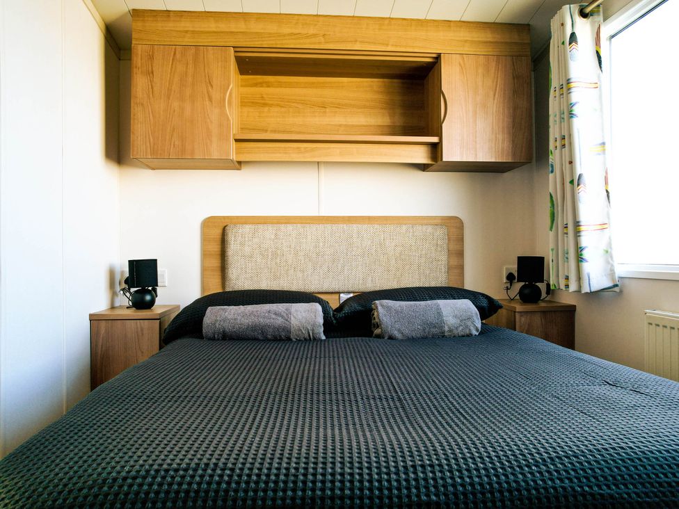A bedroom with a bed and bedside tables at Captivating 6-Person Caravan in Rhyl