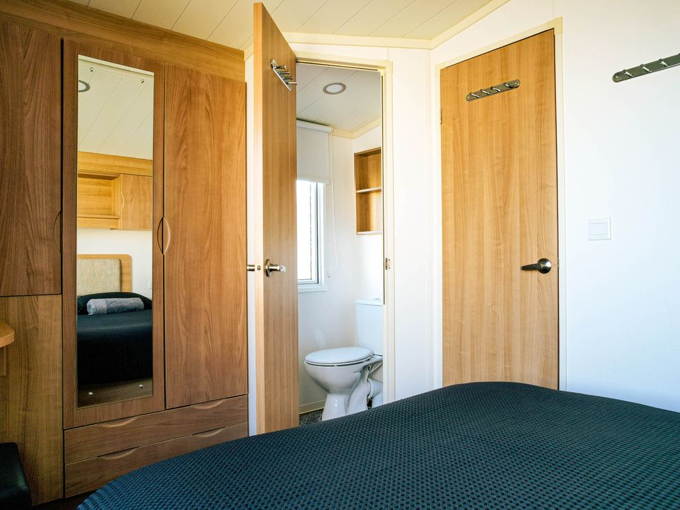 A bedroom with a bed and wardrobe at Captivating 6-Person Caravan in Rhyl