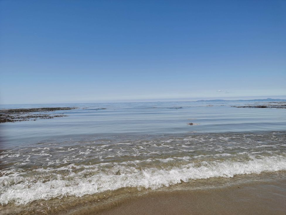 A view of the sea with waves and rocks at Sea and Mountain view Sunbeach Holiday Snowdonia in Llwyngwril