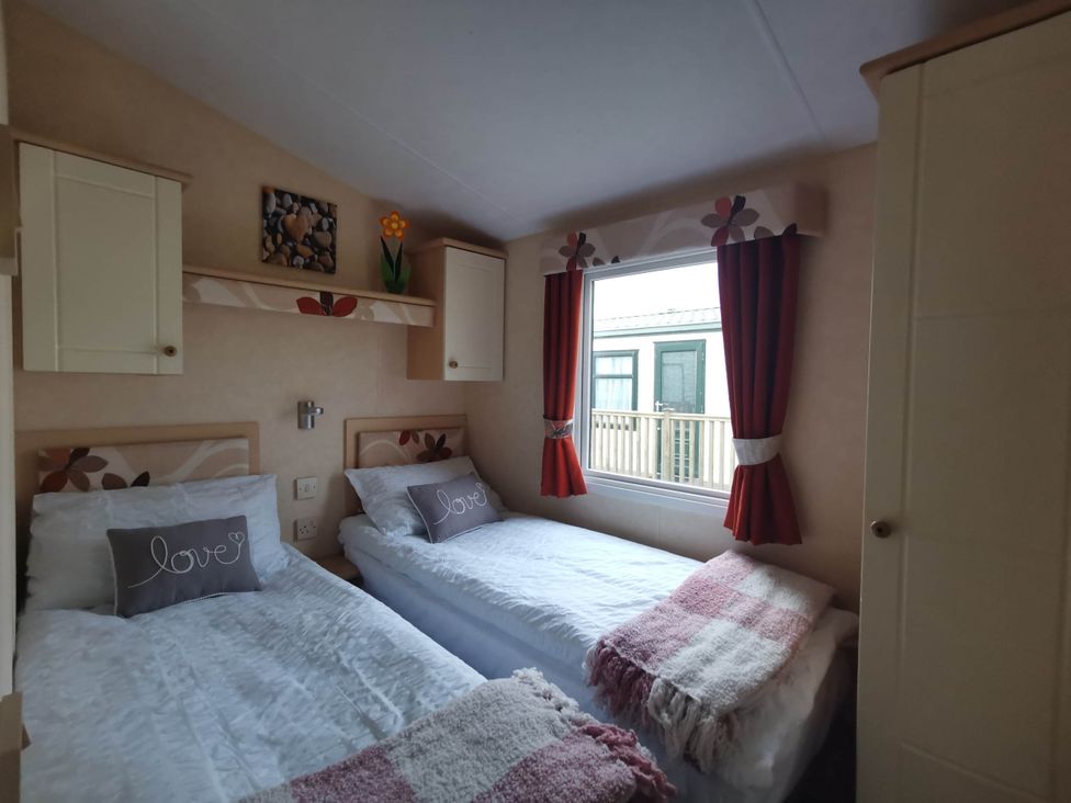 A bedroom with two single beds and a window at Sea and Mountain view Sunbeach Holiday Snowdonia Llwyngwril