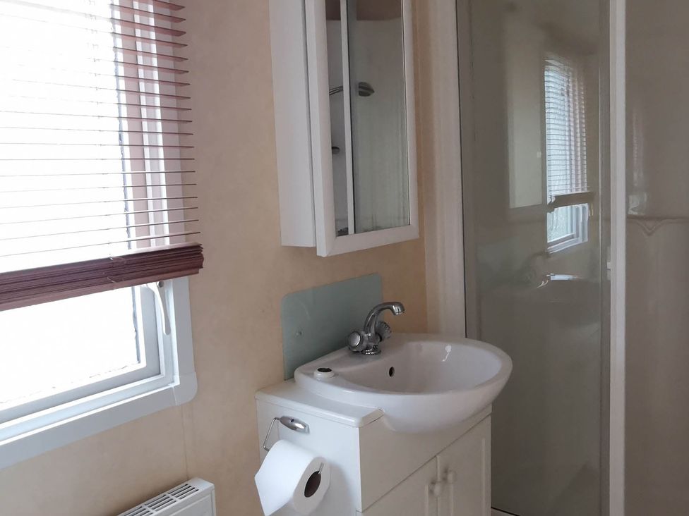 A bathroom with a sink and shower at Sea and Mountain view Sunbeach Holiday Snowdonia, Llwyngwril