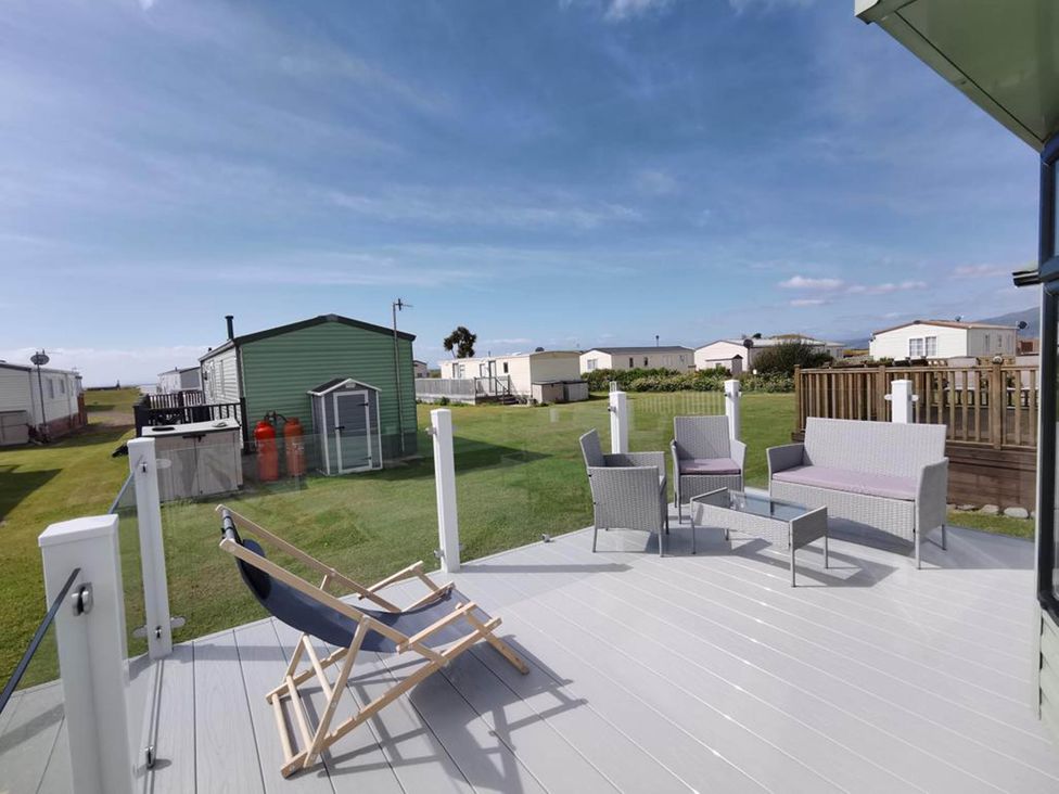 An outdoor area with seating and gas cylinders at Sea and Mountain view Sunbeach Holiday Snowdonia, Llwyngwril