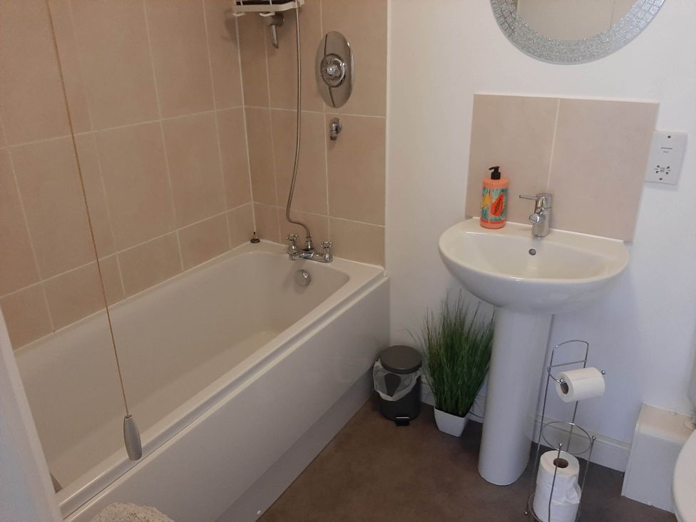 A bathroom with a bathtub and sink at Ground Floor Cornish Retreat Free Parking in Bodmin