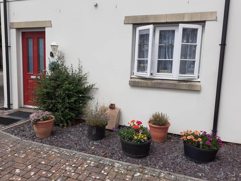 An entrance with a red door and flower pots at Ground Floor Cornish Retreat Free Parking in Bodmin