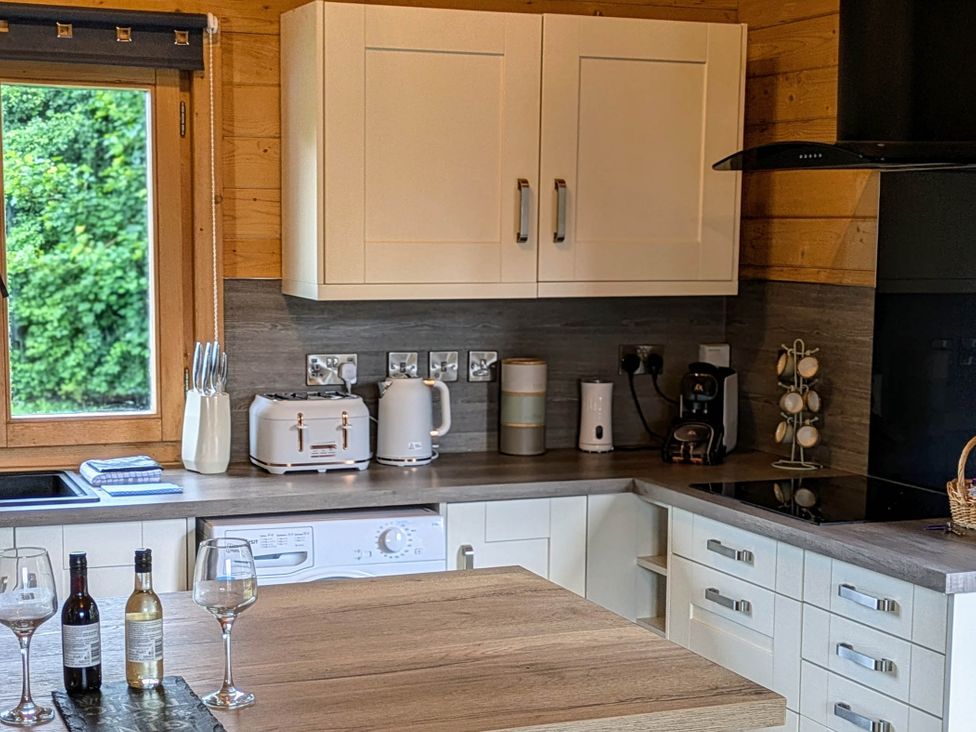 A kitchen with cabinets and appliances at Pet Friendly - Lodge at Riverview Holiday Park, Mangerton near Newcastleton