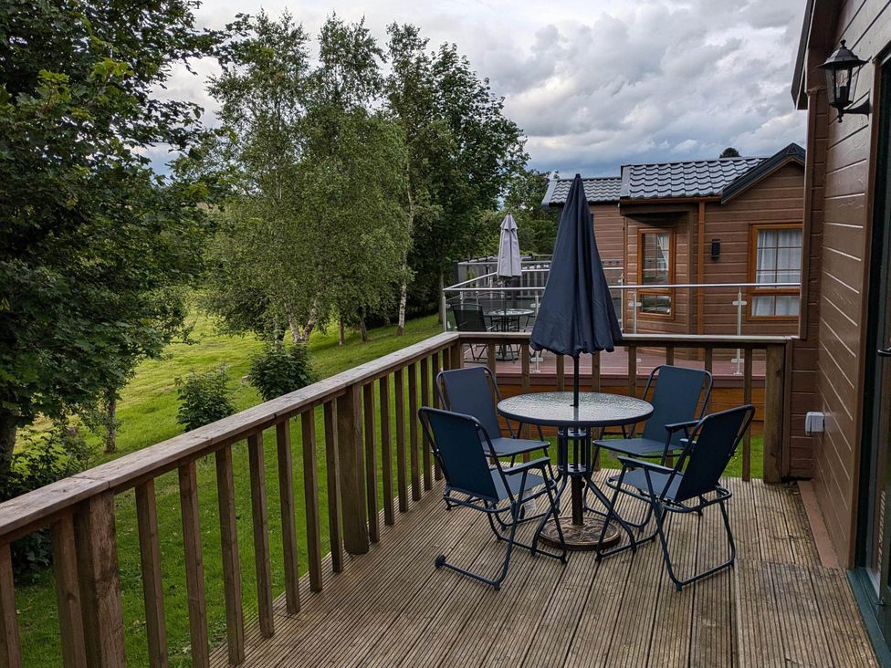 An outdoor area with a table and chairs at Pet Friendly - Lodge at Riverview Holiday Park Mangerton near Newcastleton
