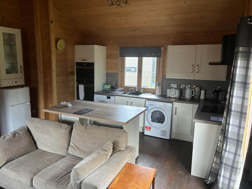 A kitchen with a washing machine and refrigerator at Pet Friendly - Lodge at Riverview Holiday Park, Mangerton near Newcastleton