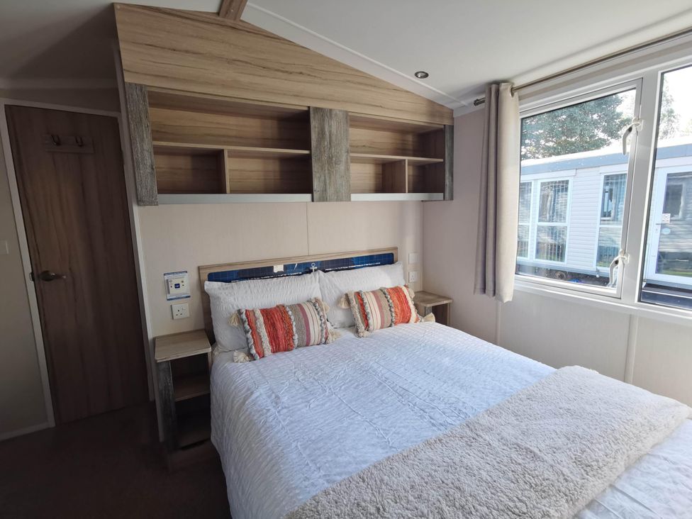 A bedroom with a bed and shelves at 8Berth- SmartTV- CloseToBeach- FamilyFriendly in Mablethorpe