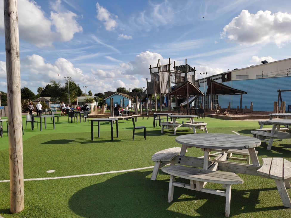 An outdoor play area with picnic tables and a climbing frame at 8Berth- SmartTV- CloseToBeach- FamilyFriendly in Mablethorpe