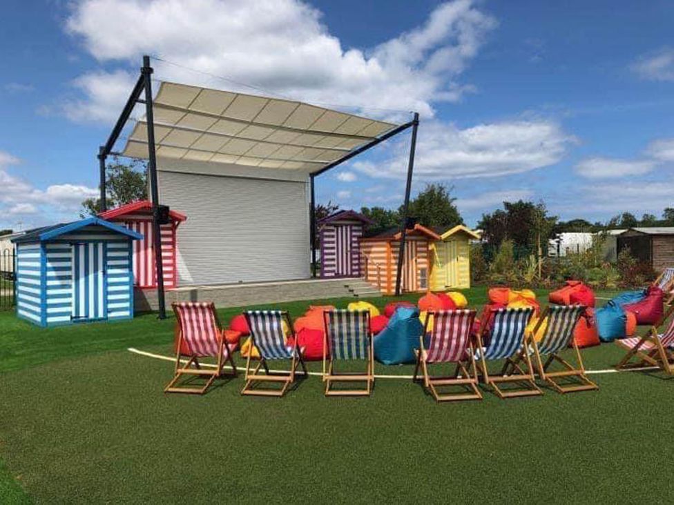 An outdoor area with a screen and colorful beach huts at 8Berth- SmartTV- CloseToBeach- FamilyFriendly in Mablethorpe
