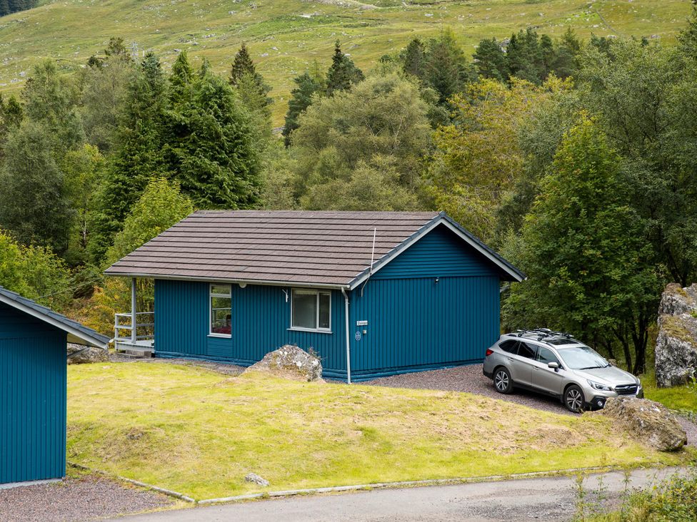 A lodge with a car parked outside at 2 bedroom lodge with stunning loch, mountain views in Crianlarich