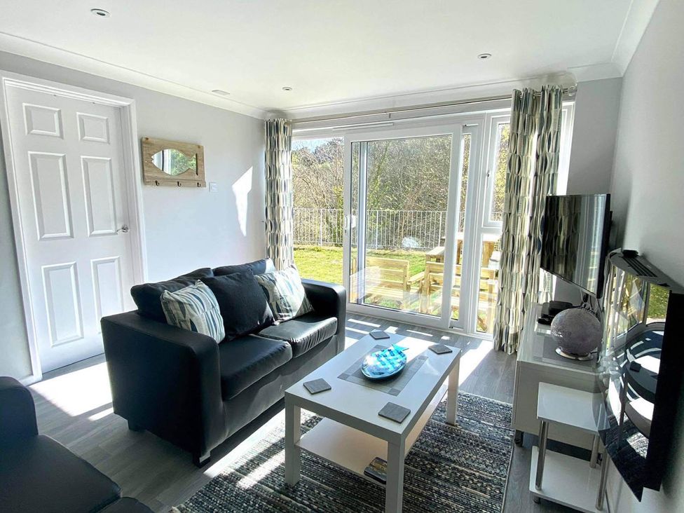 A living room with a sofa and coffee table at 8Berth- SmartTV- CloseToBeach- FamilyFriendly in Millendreath near Looe
