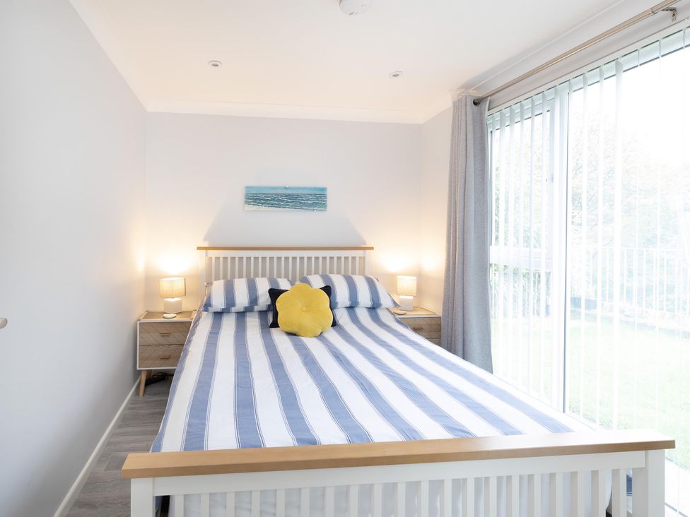A bedroom with a bed and bedside lamps at 8Berth- SmartTV- CloseToBeach- FamilyFriendly in Millendreath near Looe