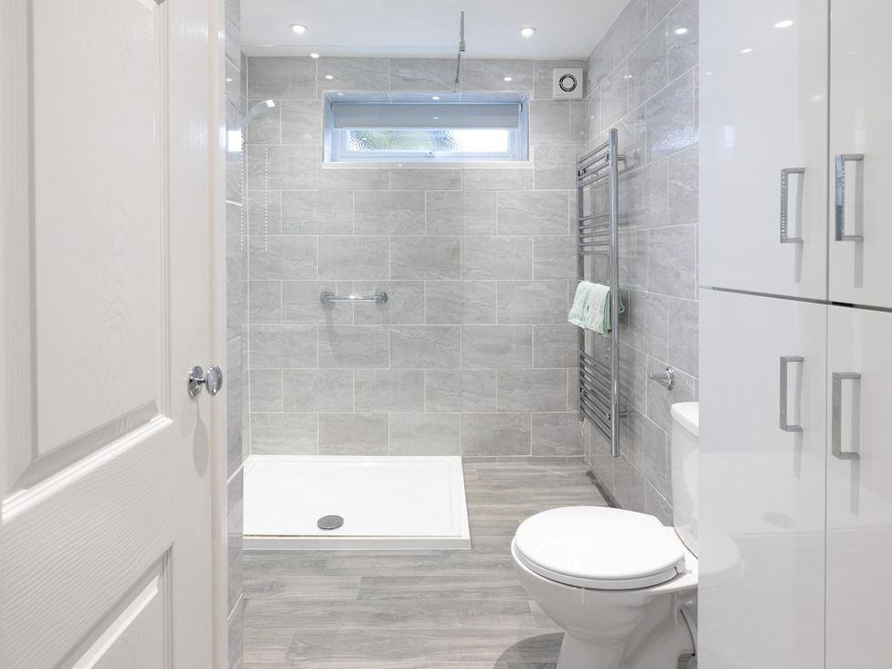 A bathroom with a shower, toilet, and towel rack at 8Berth- SmartTV- CloseToBeach- FamilyFriendly, Millendreath near Looe