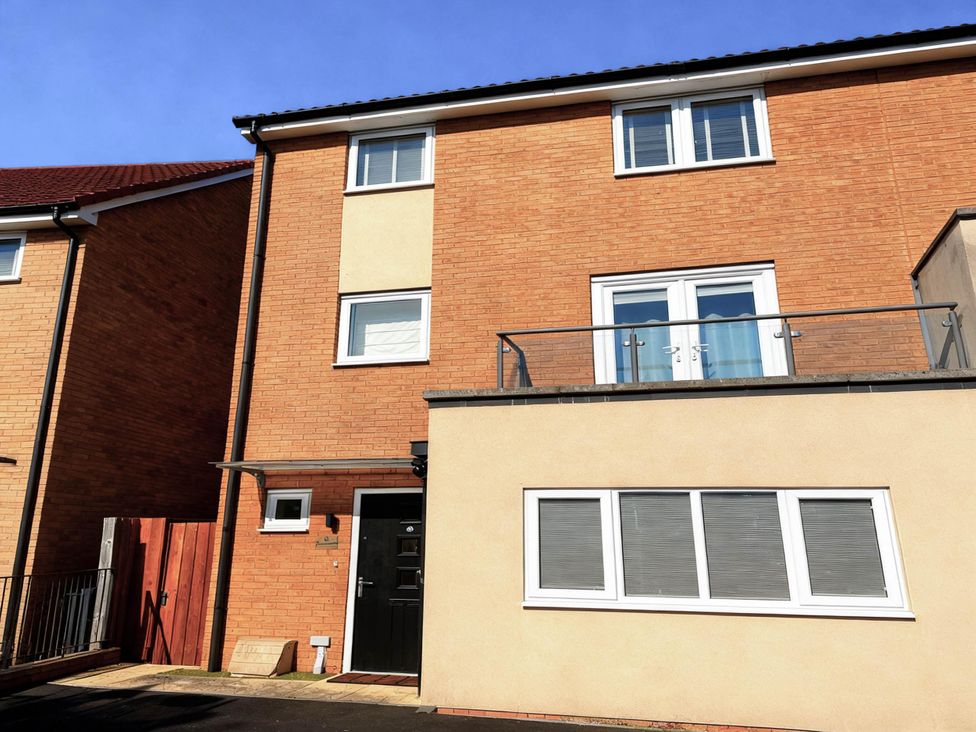 A house with a balcony and multiple windows at House Sleeps 12 with WiFi in Bristol