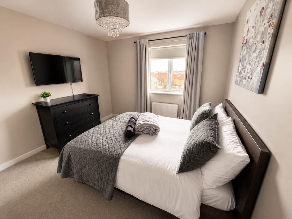 A bedroom with a bed and television at House Sleeps 12 with WiFi in Bristol