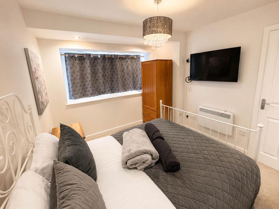 A bedroom with a bed, wardrobe, and television at House Sleeps 12 with WiFi Bristol