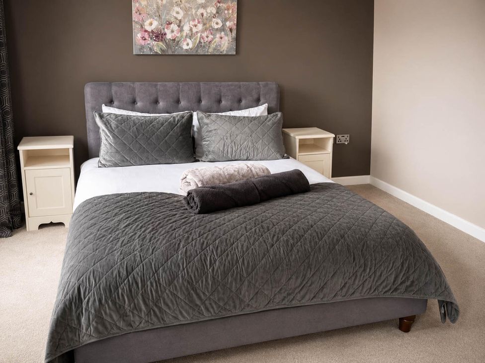 A bedroom with a bed and side table at House Sleeps 12 with WiFi, Bristol