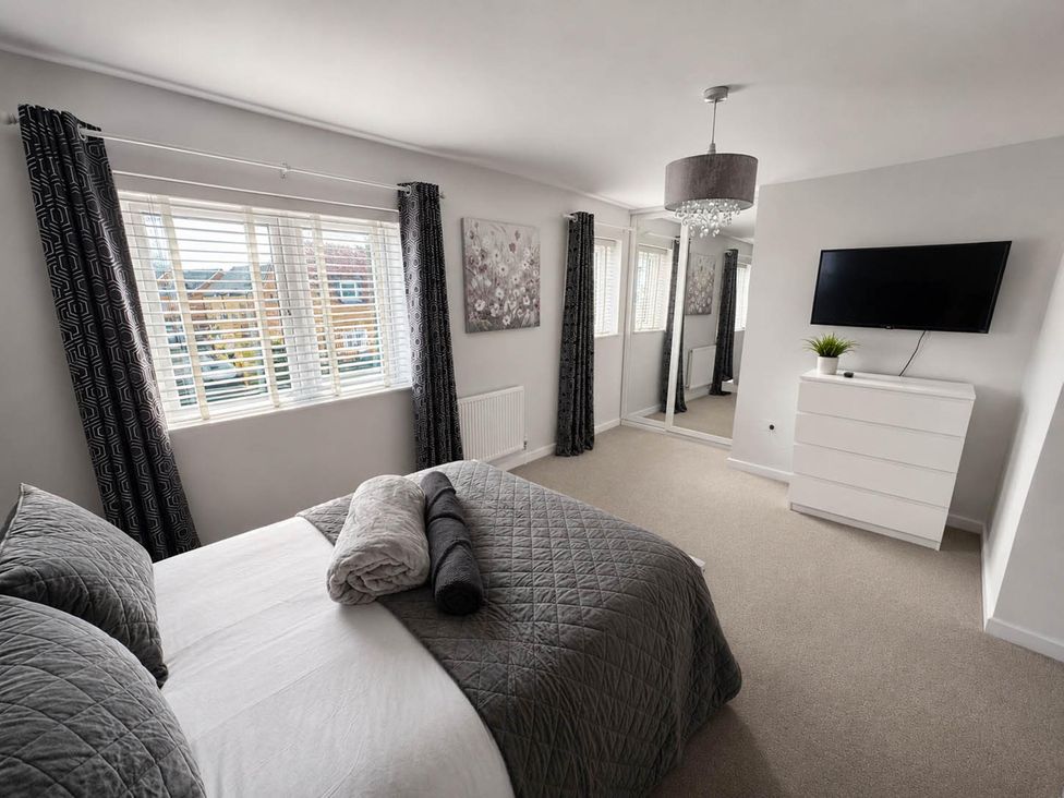 A bedroom with a bed, television and mirror at House Sleeps 12 with WiFi in Bristol