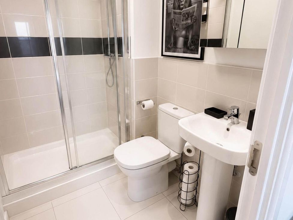 A bathroom with a shower, toilet, and washbasin at House Sleeps 12 with WiFi Bristol