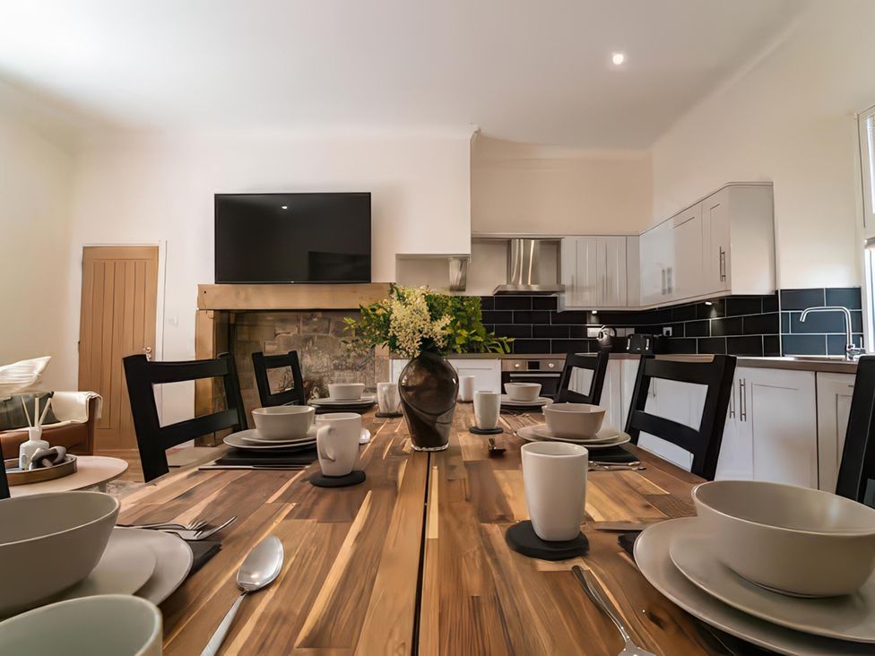 A dining area with a wooden table and chairs at Foundry Farm Apartment 