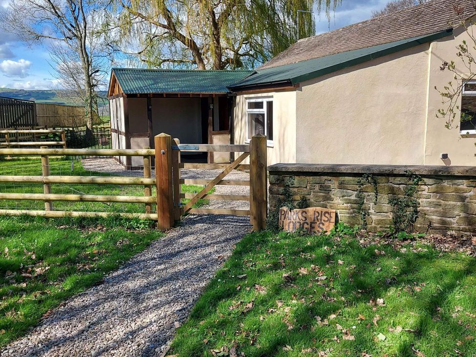A pathway leading to a lodge with a wooden gate at Parks Rise Lodges near Hay-On-Wye