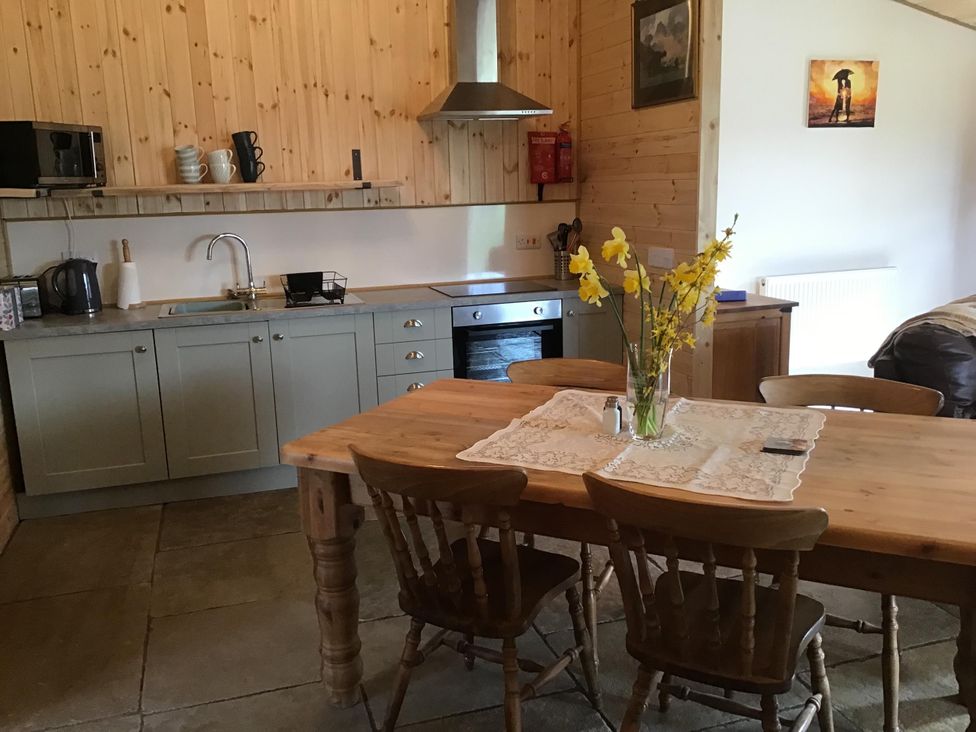 A kitchen with a dining table and appliances at 1 Bed Lodge-Sleeps 4-Pet Friendly-Free Parking near Hay-On-Wye