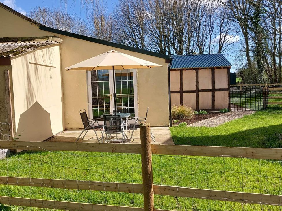 A garden with a table and chairs near a shed at 1 Bed Lodge-Sleeps 4-Pet Friendly-Free Parking near Hay-On-Wye