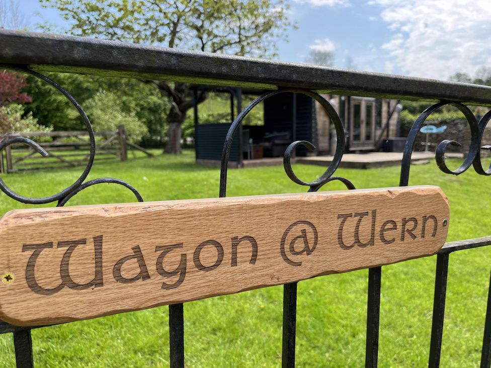A sign that reads Wagon @ Wern in an outdoor area with grass and trees