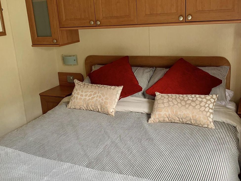 A bedroom with a bed and pillows at Static Caravan 2 Bedrooms - sleeps 4 in Hawick