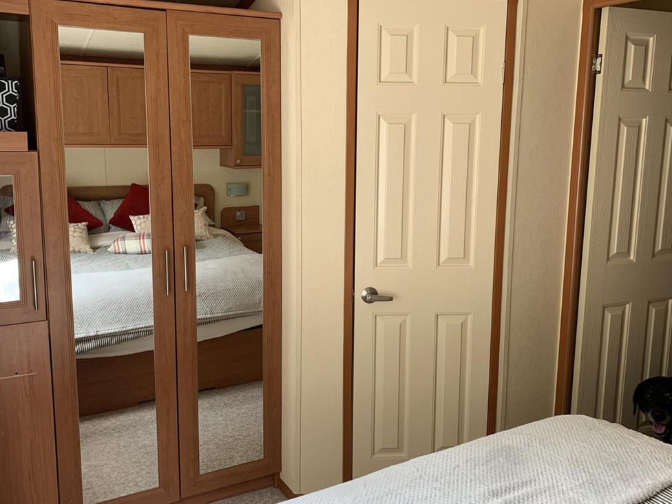 A bedroom with a bed and wardrobe at Static Caravan 2 Bedrooms - sleeps 4 in Hawick