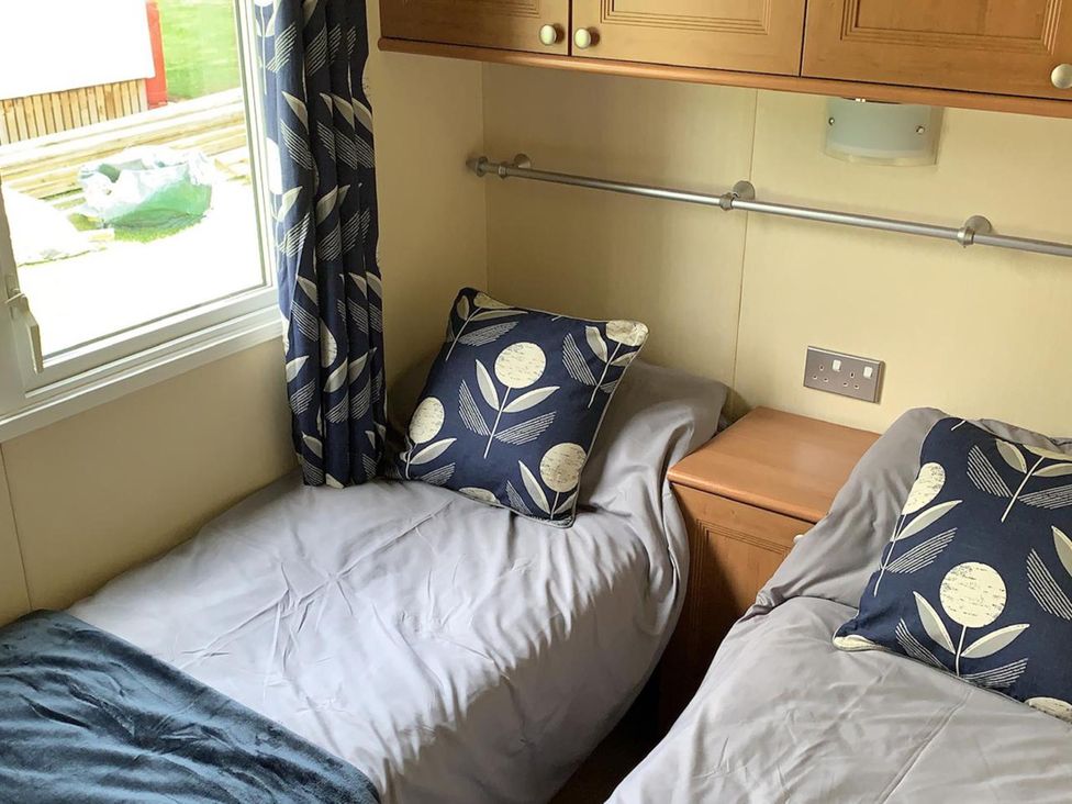 A bedroom with two beds and a bedside table at Static Caravan 2 Bedrooms - sleeps 4 in Hawick