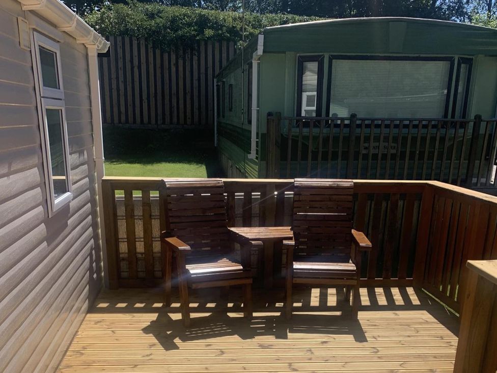 A deck area with wooden chairs at Static Caravan 2 Bedrooms - sleeps 4 in Hawick
