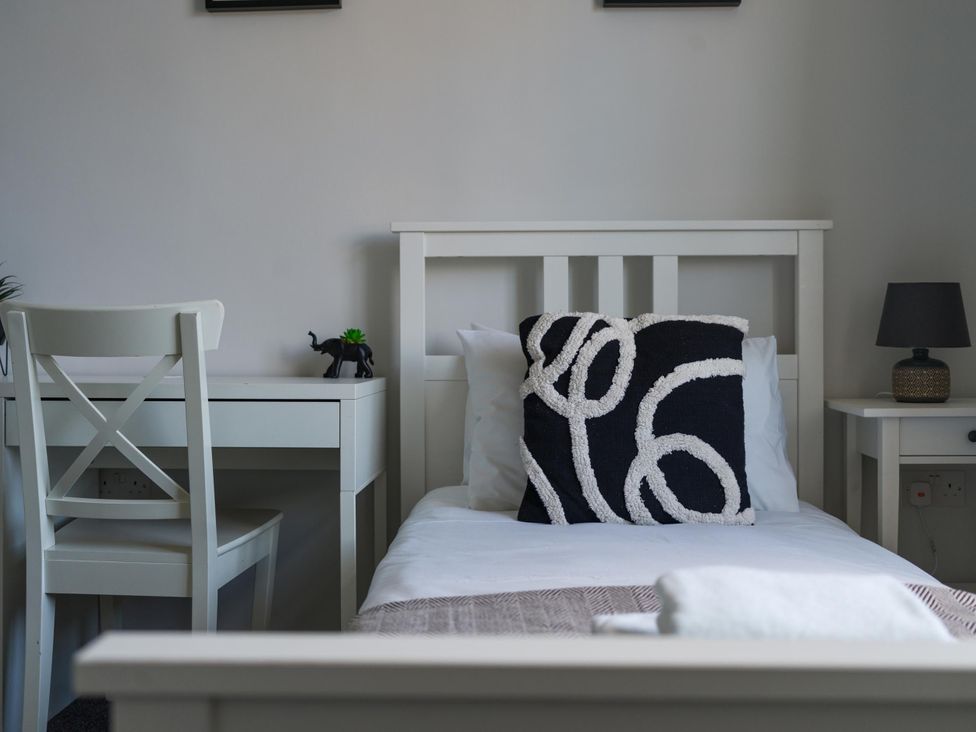 A bedroom with a bed, desk, chair, and lamp at Lily Apartment - Sleeps 3 - Pet friendly - Parking, Bedlington