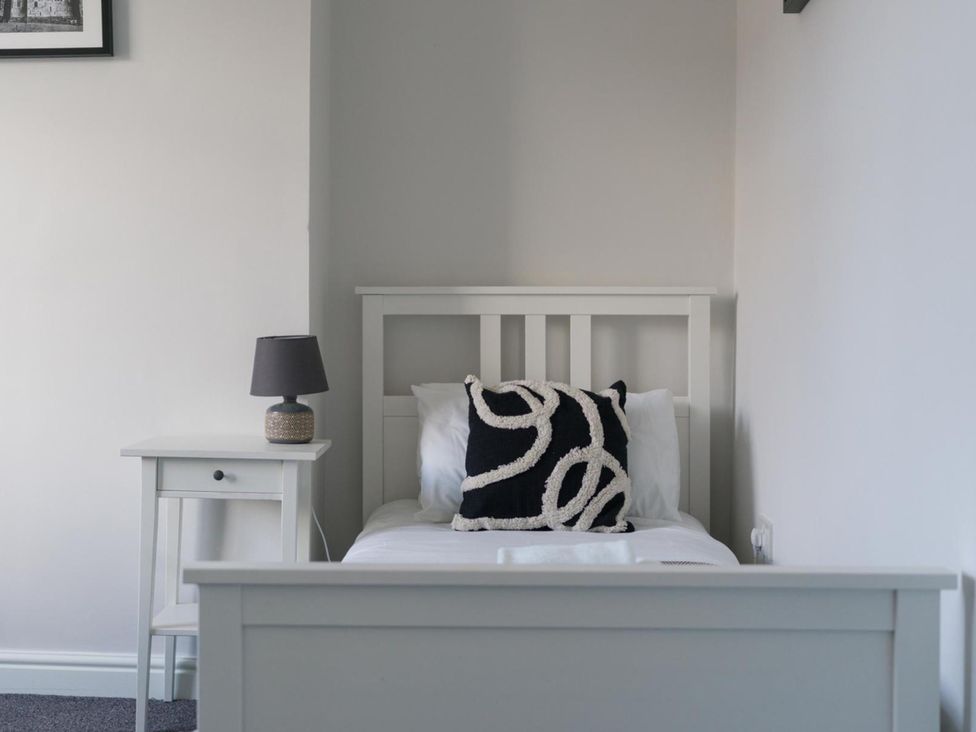 A bedroom with a bed, side table and lamp at Lily Apartment - Sleeps 3 - Pet friendly - Parking Bedlington