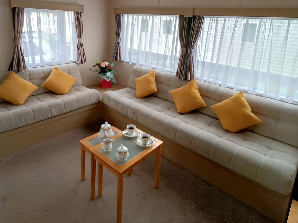 A living room with a table and sofa at 3 Bed, Sleeps 6, Parking