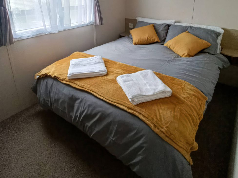 A bedroom with a bed and towels at 3 Bed, Sleeps 6, Parking