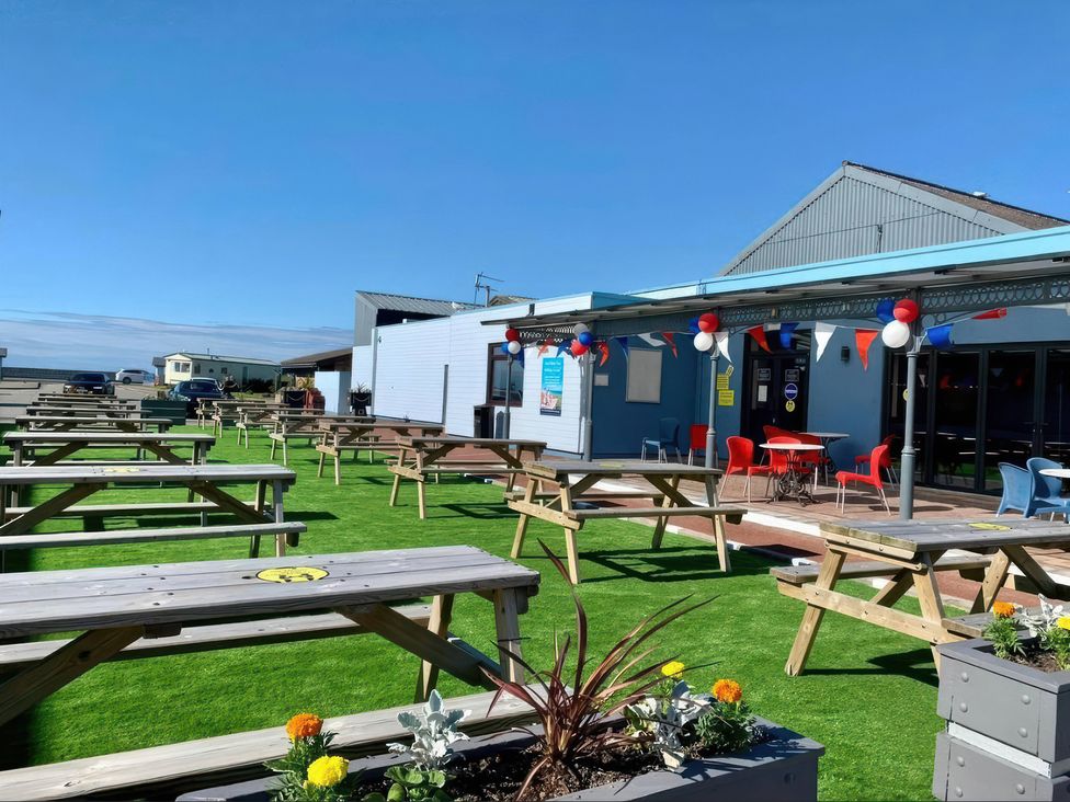 An outdoor seating area with tables and flowers at a venue