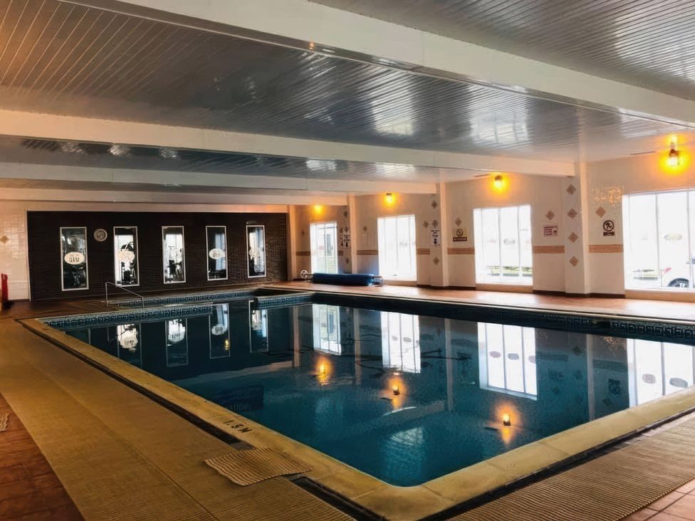 An indoor pool with large windows and lighting at 3 Bed, Sleeps 6, Parking