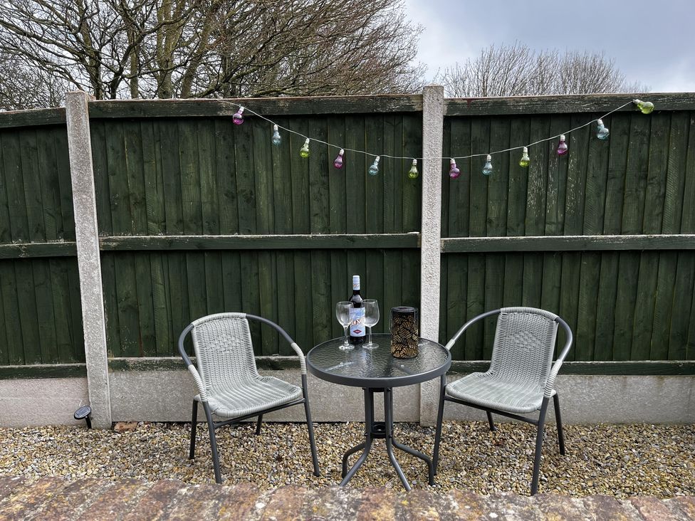 An outdoor seating area with a table and chairs at TBC in 