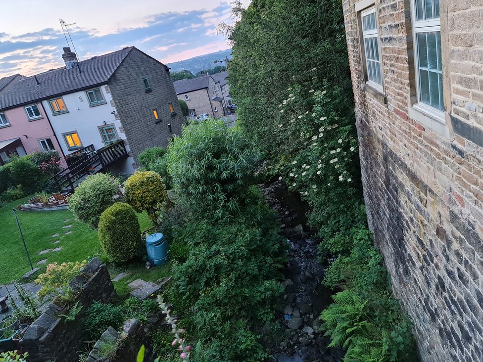 A garden with houses and a stream at TBC