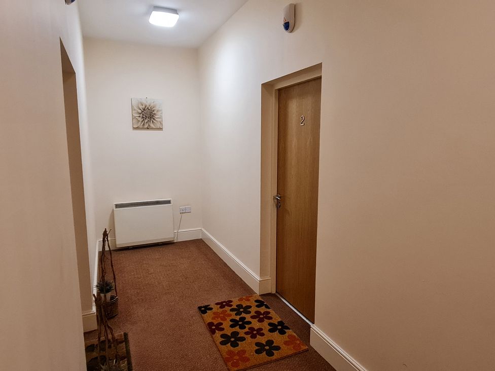 A hallway with a door, heater, and wall decoration at TBC in 