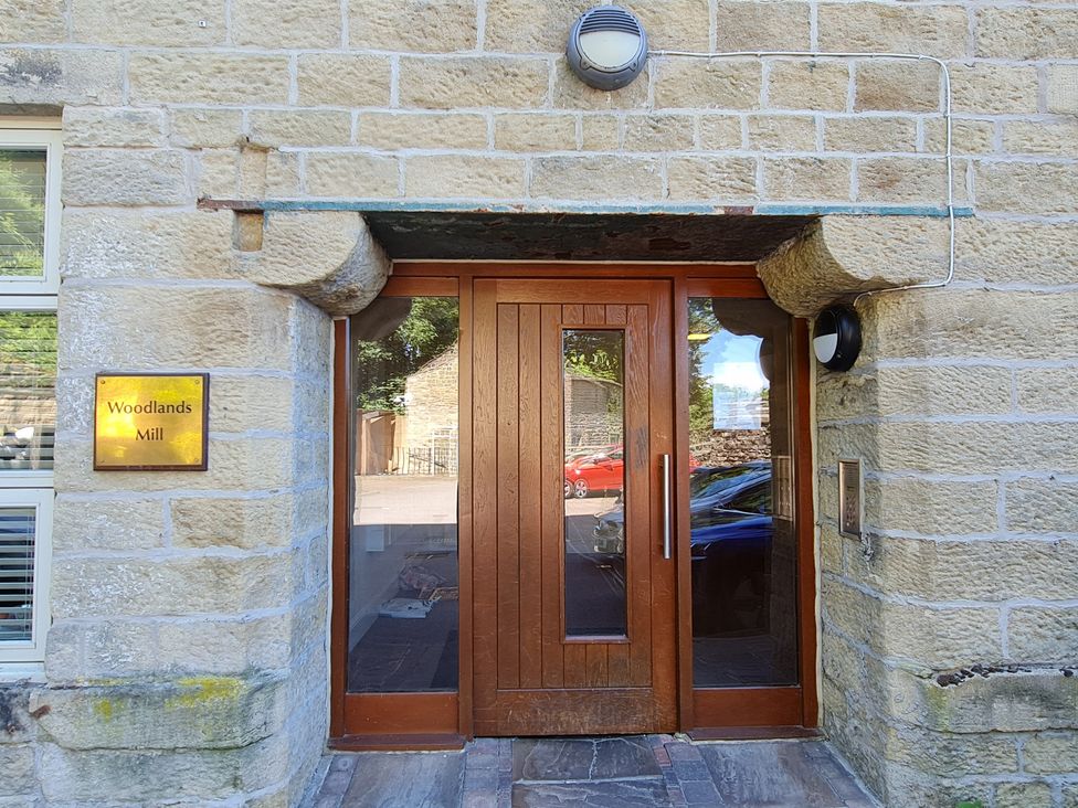 An entrance with wooden doors and a nameplate at Woodlands Mill