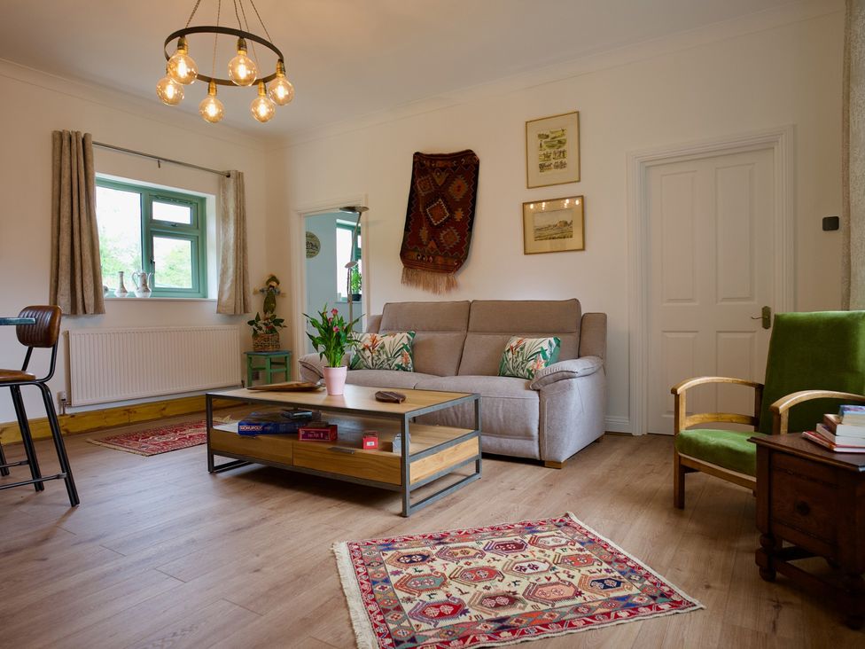 A living room with a sofa coffee table and armchair at TBC 