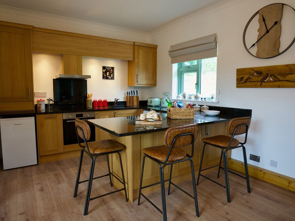 A kitchen with a countertop, stools, and appliances at TBC in 