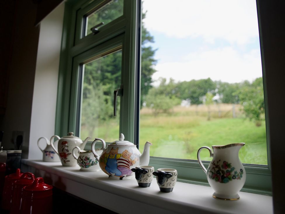 A kitchen window with a tea set displayed on the sill at TBC